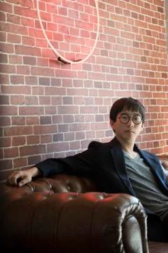 Man sitting on sofa, portrait Stock Photos