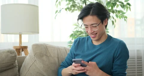 Man sitting on sofa using mobile phone Video stock 145290831