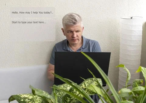 A man sitting on a sofa while looking at a screen of a laptop, engaging wit.. Stock Photos
