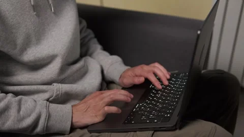 Man sitting on sofa working on laptop in indoor space. Calm evening atmosphere Stock Footage 314555586