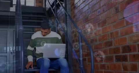 Man sitting on stair with laptop, tapping device and picking up smartphone, Stock Footage 334115609
