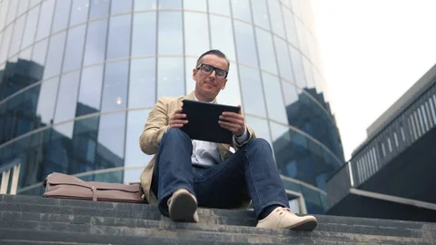 Man sitting at stairs and using tablet pc Stock Footage 92088859