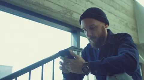 Man sitting on stairs using smartphone Stock Footage 62948089