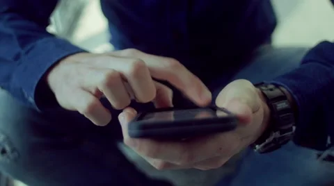 Man sitting on stairs using smartphone Stock Footage 62948107