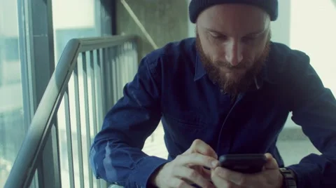 Man sitting on stairs using smartphone Stock Footage 62948120