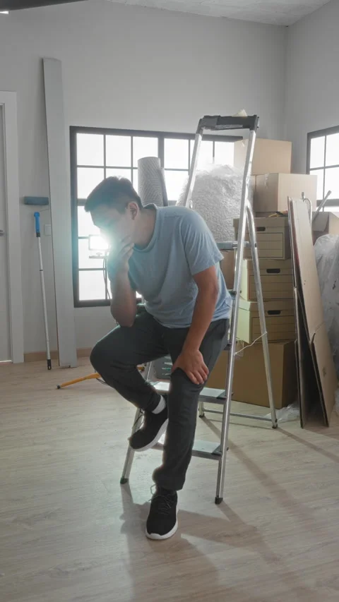 Man sitting on a step ladder with hand on cheek and holding head among pack.. Stock Footage 337355768
