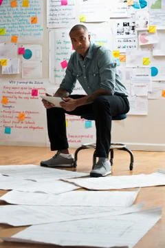 Man sitting on stool with digital tablet Foto stock