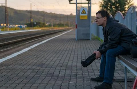 Man sitting on the street on the platform Stock Photos