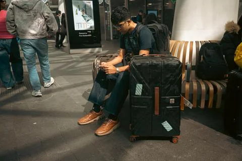 Man Sitting with Suitcases Inside a Train Station Stock Photos