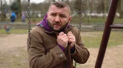 Man sitting on the swing on cold day  Stock Footage 60962833