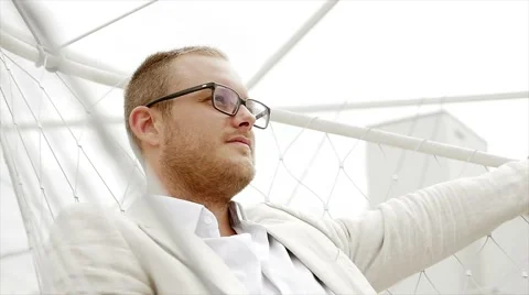 Man sitting on swing outdoors seining around relaxing. casual lifestyle Video stock 42948485