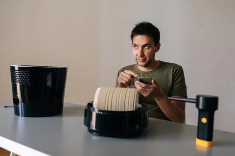 Man sitting at table and cleaning air humidifier filter, using instructions or Stock Photos