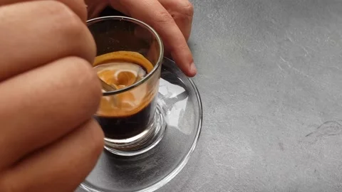 Man sitting at the table and mixing coffee, closeup Stock Footage 144791355