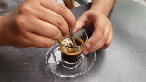 Man sitting at the table and mixing coffee, closeup Stock Footage 144791597
