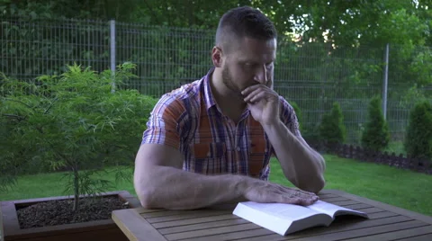 Man sitting at the table and reading book. 库存影片 52689413