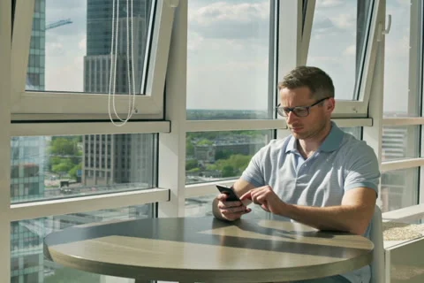Man sitting at the table and talking on cellphone Stock Footage 50569754
