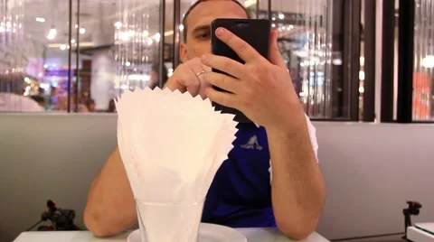 Man sitting at table in cafe using mobile phone while waiting for his food. HD. Video stock 44467666