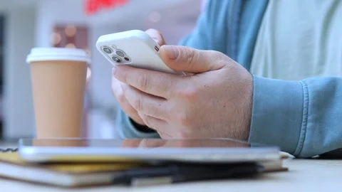 Man is sitting at a table with a cell phone in his hand Stock Footage 310224596