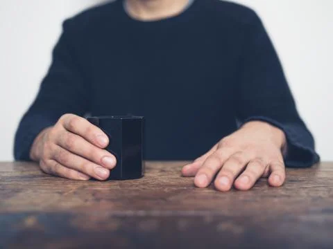 Man sitting at table with cup 库存照片