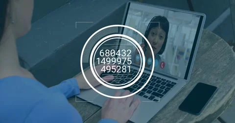 Man sitting at table getting data using laptop watching HUD overlay updating Stock Footage 329122351
