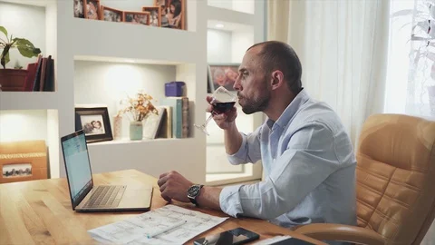 A man sitting at a table at home The man is working and drawing. Engineering Stock Footage 129808616