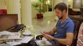 Man sitting at table in hotel lobby and checking morning news, a coffee on table HD Footage