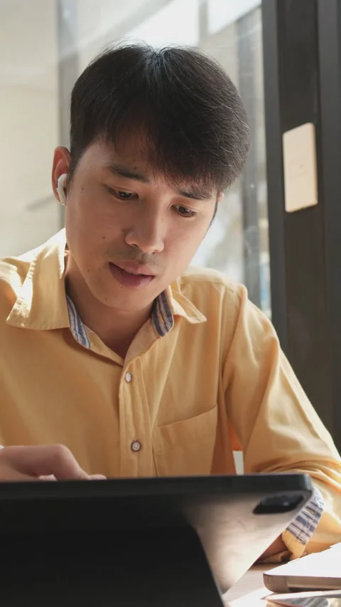 A man is sitting at a table with a laptop and a pen Stock Footage 308566044