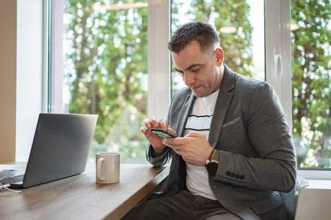 Man Sitting at Table Looking at Cell Phone Stock Photos