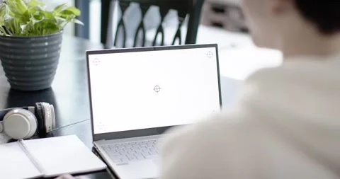 Man sitting at table near window responding to blank laptop screen with Stock Footage 348402047
