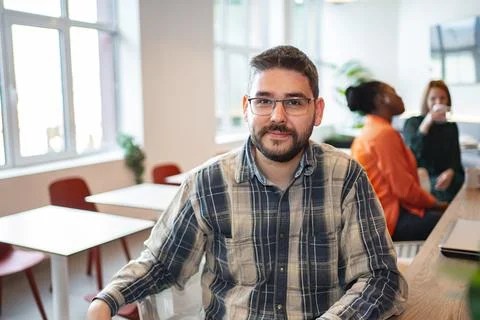 A Man Sitting at a Table in a Room Stock Photos