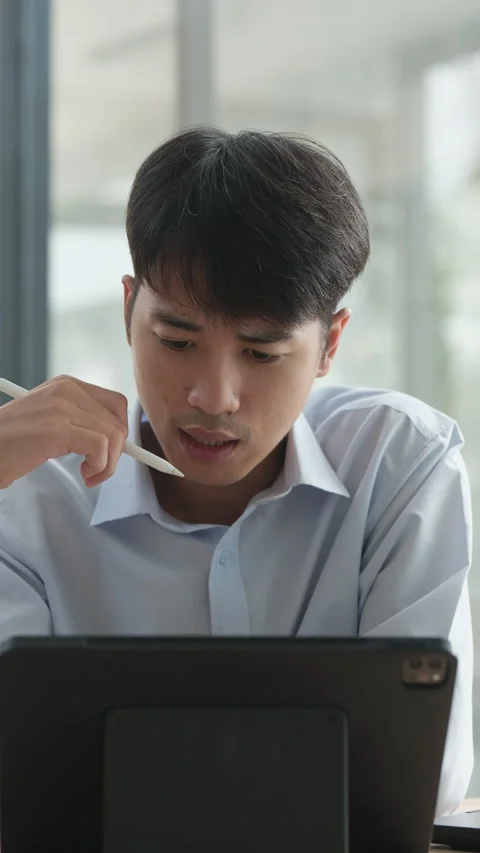 A man is sitting at a table with a tablet in front of him Stock Footage 308528806