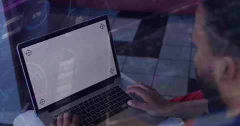 Man sitting at table, tapping trackpad while starting HUD for UI mockup showing Stock Footage 333837107