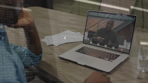 Man sitting table tech call, speaker gesturing causing code overlay scrolling on Stock Footage 320650898