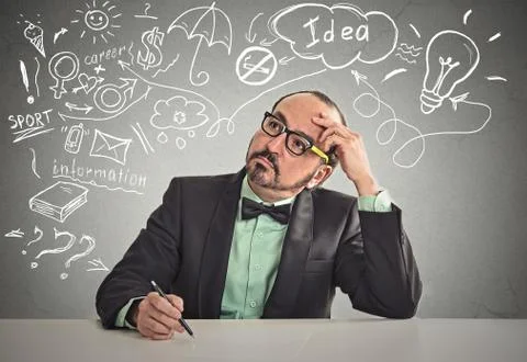 Man sitting at table thinking ready to write something Stock Photos