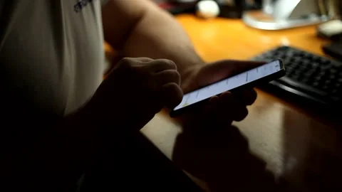 A man sitting at the table uses a smartphone. Stock Footage 152596084