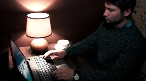 Man sitting at the table working on laptop and drinking coffee Stock Footage 56251056