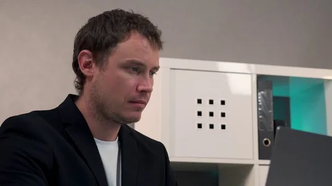 Man sitting at table working on laptop Stock Footage 128998314