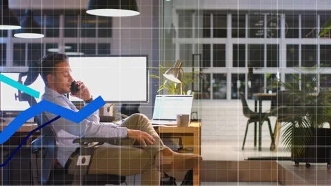 Man sitting, talking phone, glancing laptop and reaching cup while live metrics Stock Footage 332592236