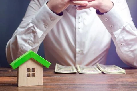 The man is sitting thinking over the sorted money. Expense planning and fin.. Stock Photos