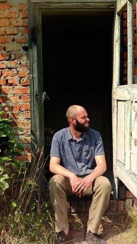 Man Sitting on Threshold of Old Rustic Brick House Stock Footage 339620336