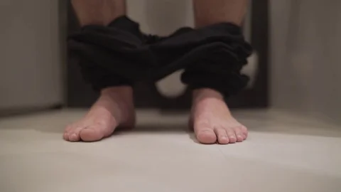 Man sitting on toilet Stock Footage 71898587