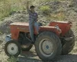 Man sitting on tractor and waving to camera SD Footage