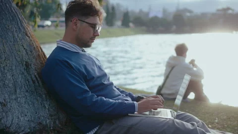 Man Sitting by Tree Outdoors Using Laptop Stock-Footage 237056025