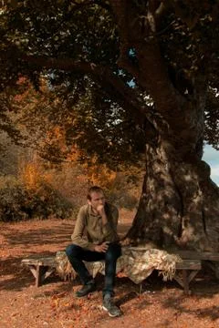 A man sitting under a tree in the forest Stock Photos