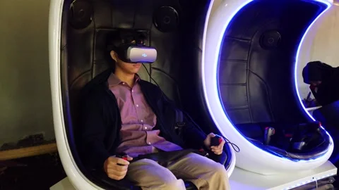A Man Sitting on Virtual Reality Game Capsule, Floating Market Lembang Stock Footage 130249466
