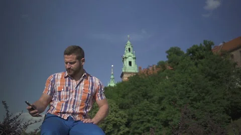 Man sitting on the wall and answering smartphone. 库存影片 52624741