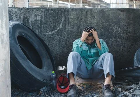 A man sitting by a wall Foto stock