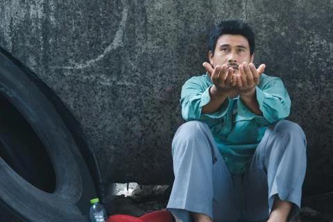 A man sitting by a wall 스톡 사진