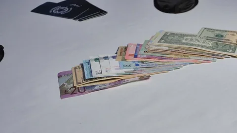 A man sitting at a white table raises a wad of money and throws it on the table. 스톡 동영상 104618809