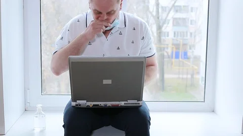 A man is sitting on the windowsill of a house Stock Footage 128002526